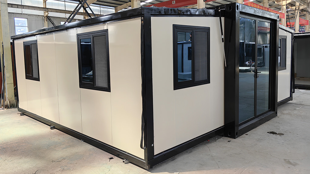 Cream-coloured expandable modular granny flat with black window frames and sliding doors