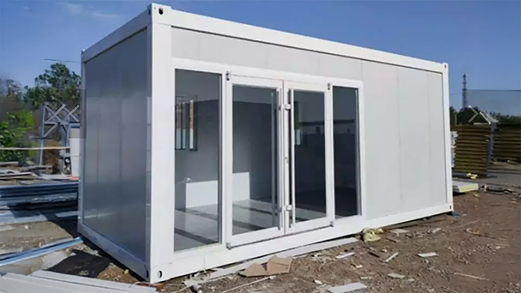 Prefabricated modular worker unit with large glass double doors on construction site